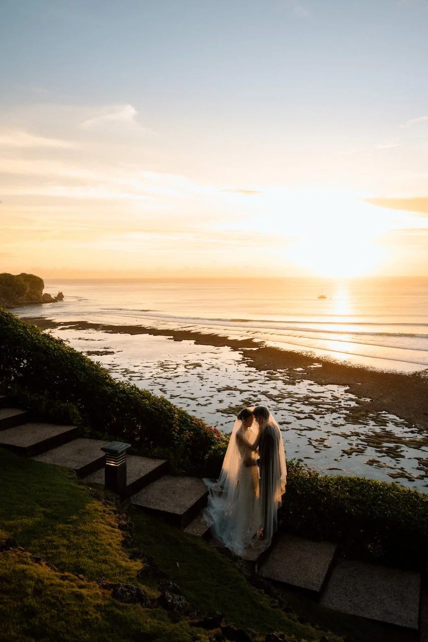 Romantic sunset portrait of a bride and groom by the ocean at Villa Pemutih.