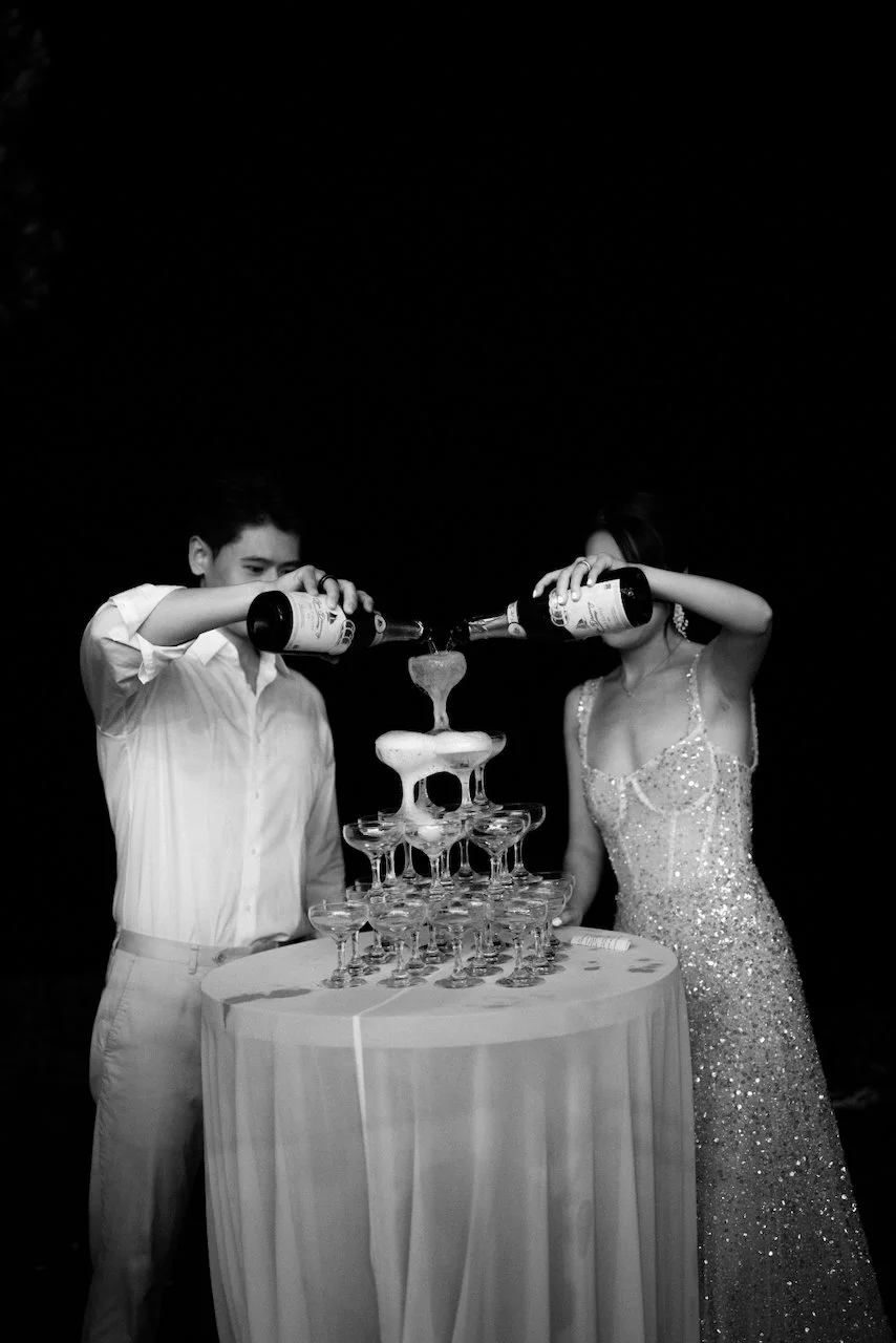 Bride and groom pouring a champagne tower at their Bali wedding reception.