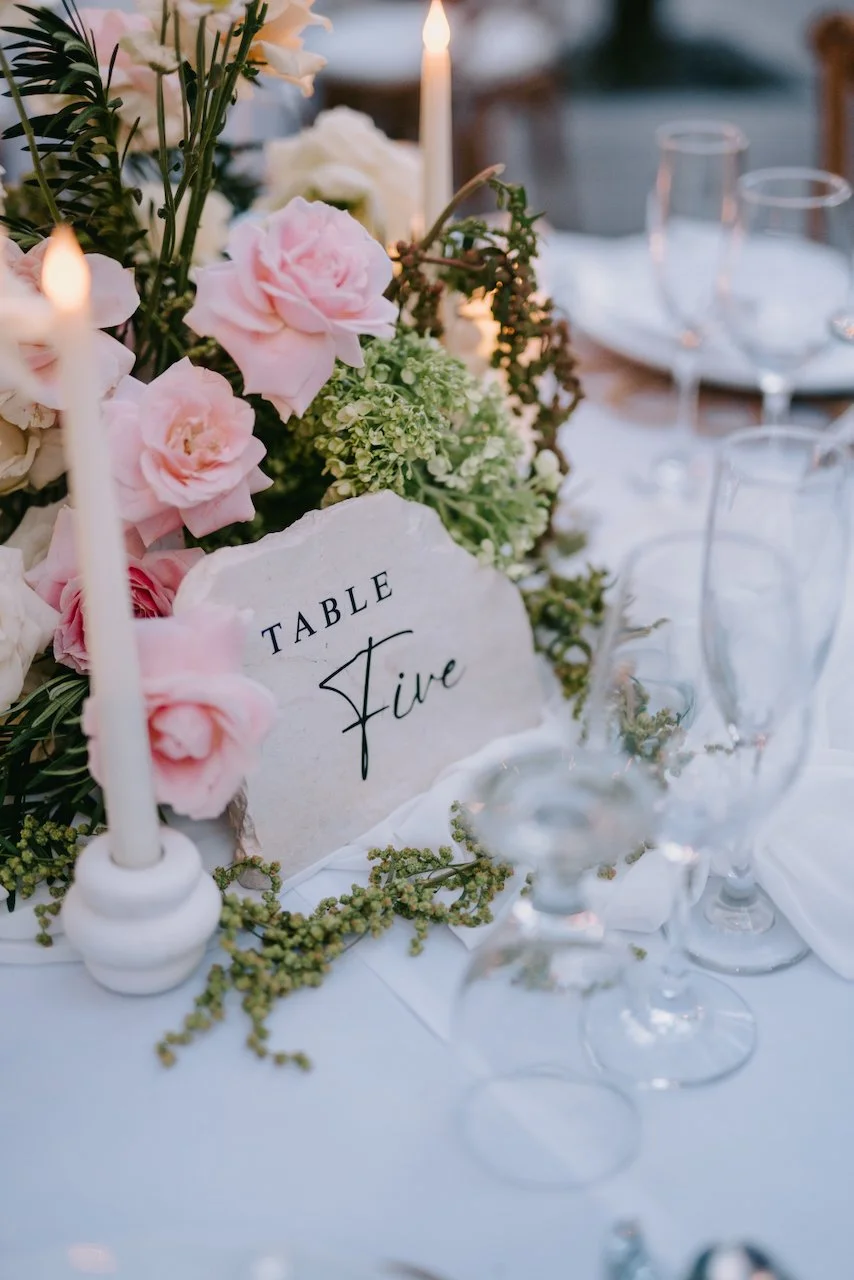 Elegant reception table styling with floral centrepieces and personalised place settings.