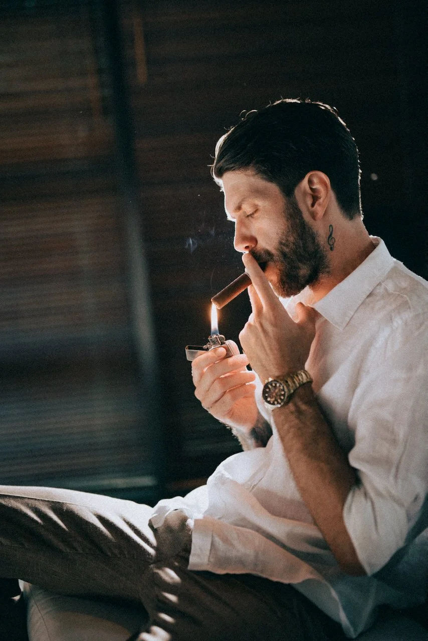 Groom getting ready before his destination wedding in Seminyak, Bali, smoking a cigar.
