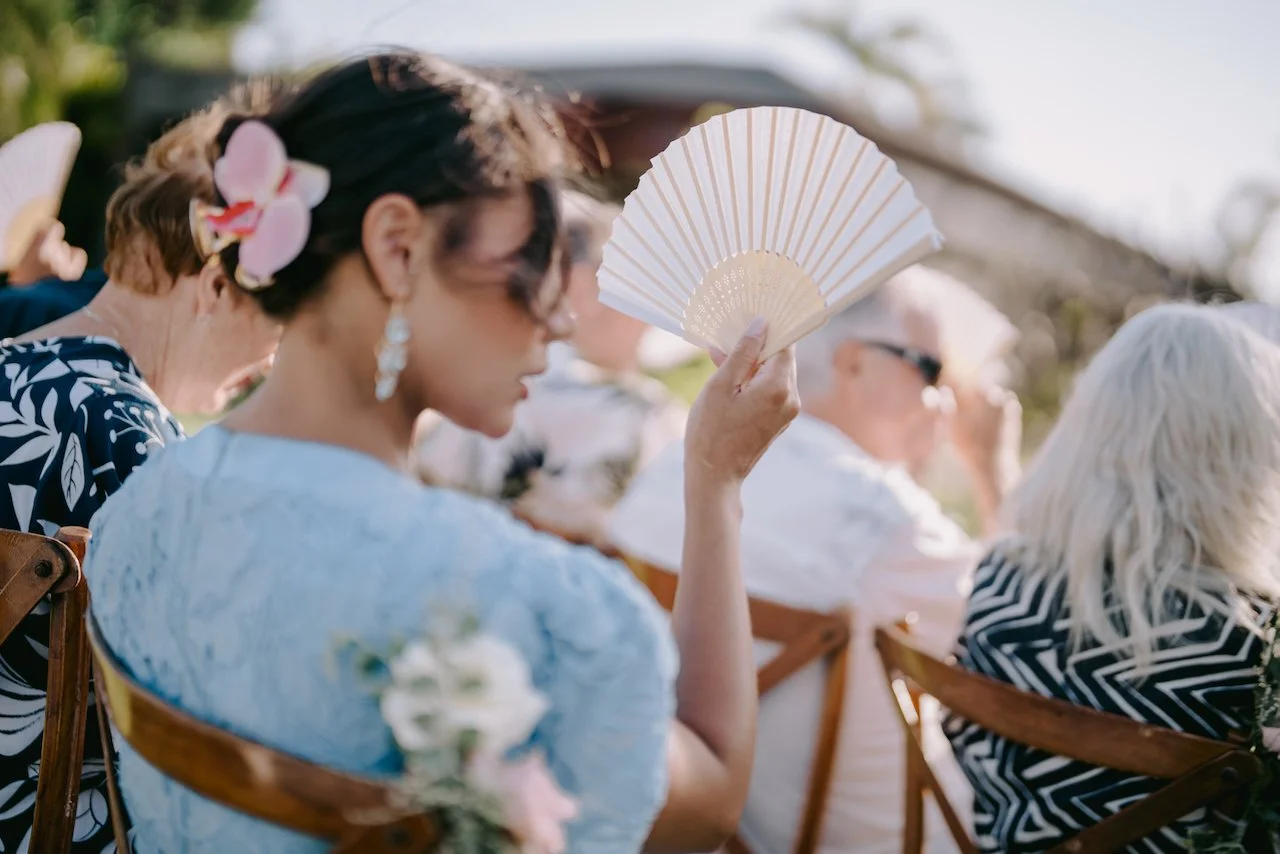 Wedding guest keeping cool during an outdoor ceremony in tropical Bali.