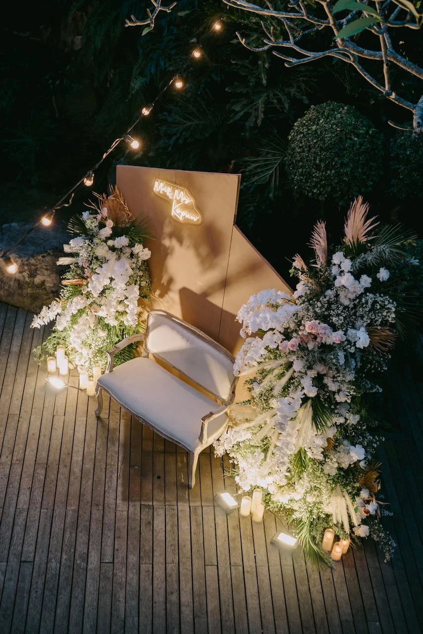 Floral sweetheart chair with romantic candlelit styling at the reception.