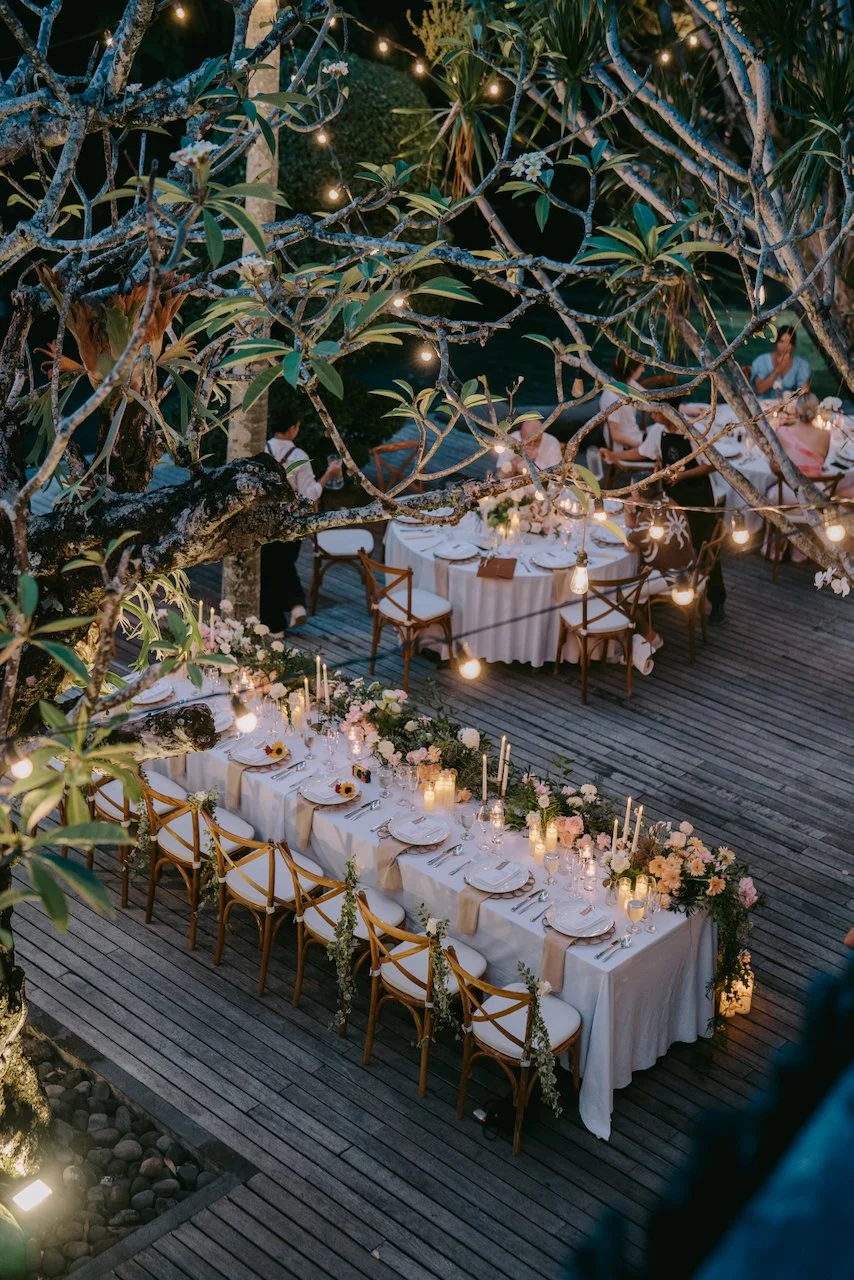 Long reception tables styled beneath the trees at Peppers Seminyak.