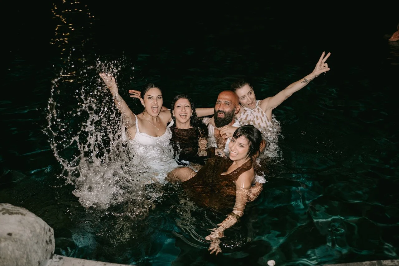 Guests celebrating together in the pool at the Bali wedding reception.