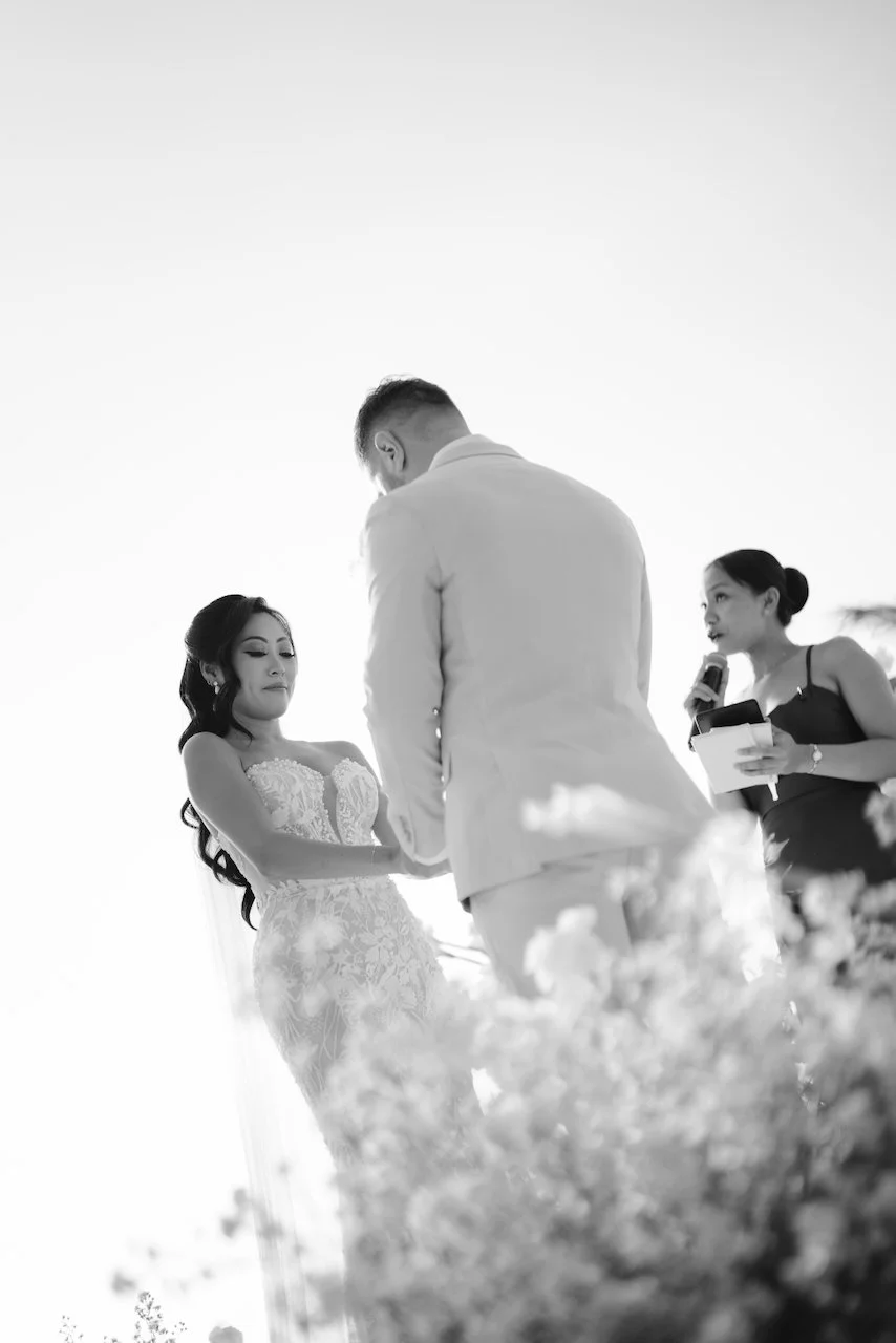 Black and white photo of the bride and groom standing amidst lush white flowers at their Bali wedding