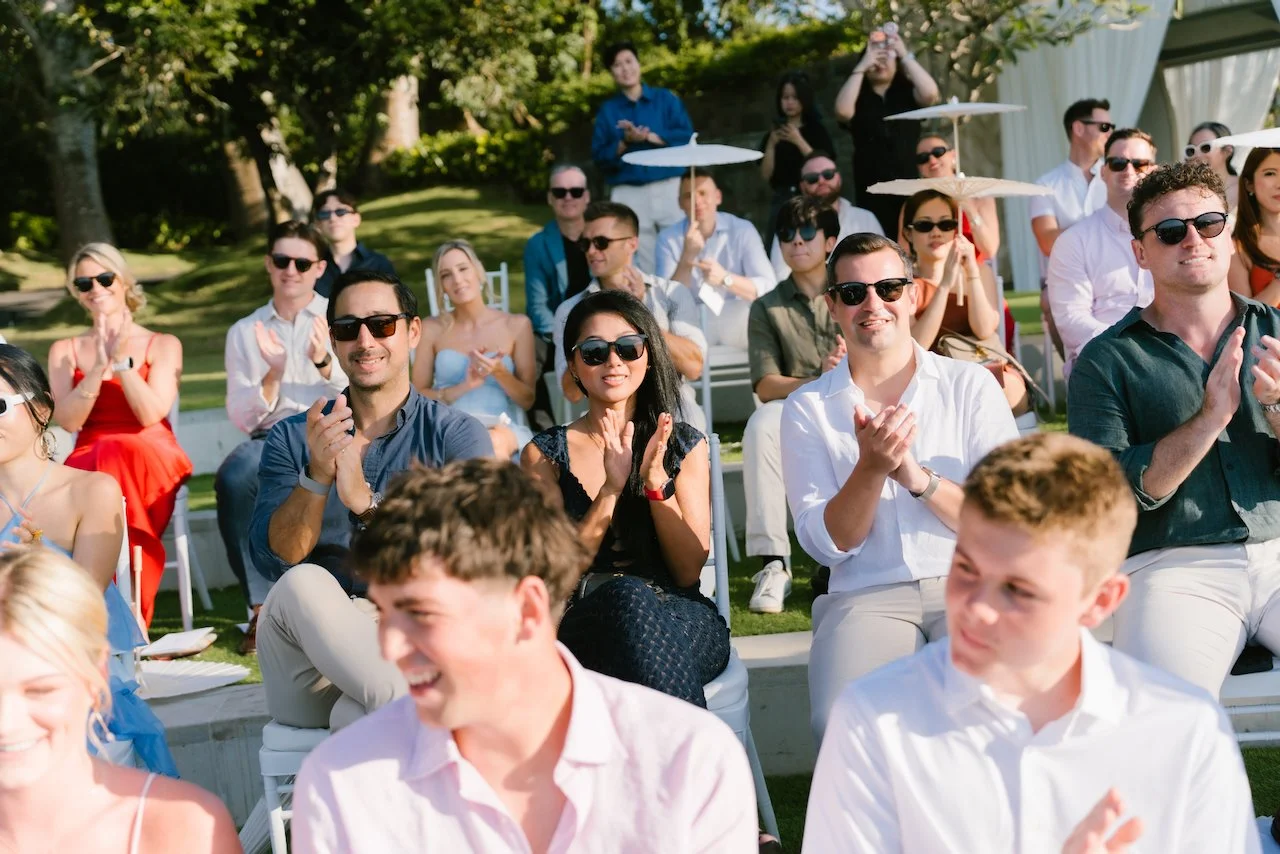 Happy wedding guests applauding and smiling during the outdoor ceremony in Bali