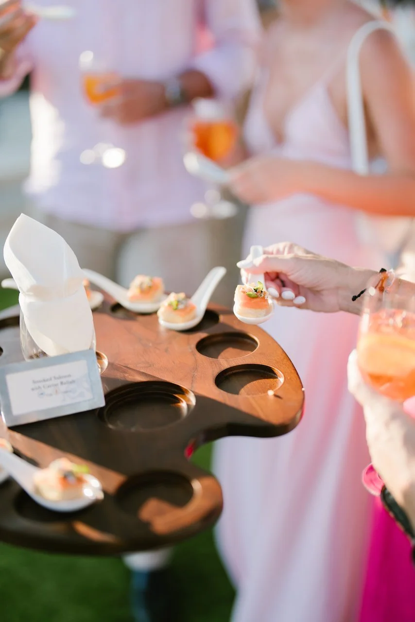 Guests holding drinks and enjoying cocktail hour on the lawn at Ayana Resort