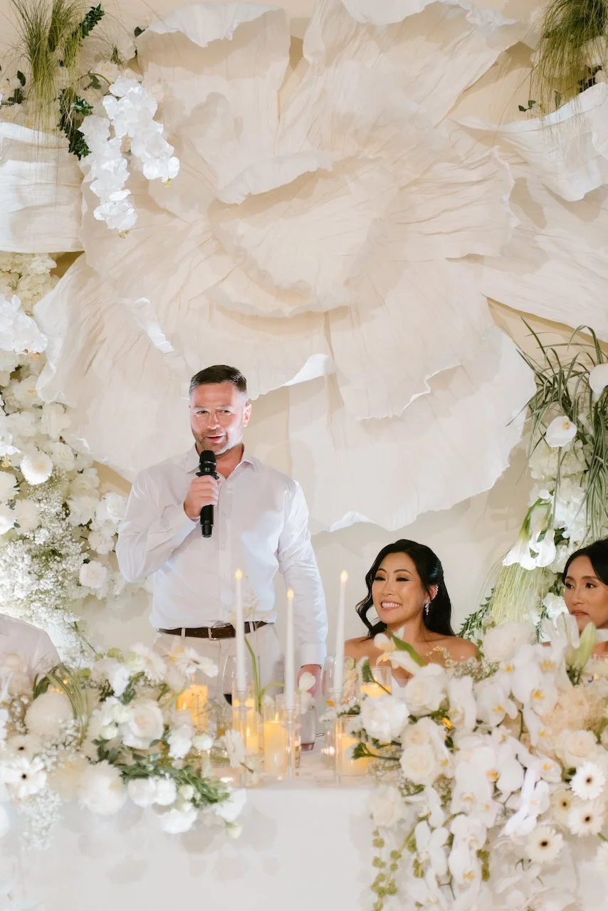 High-angle view of groom Thomas giving a reception speech.