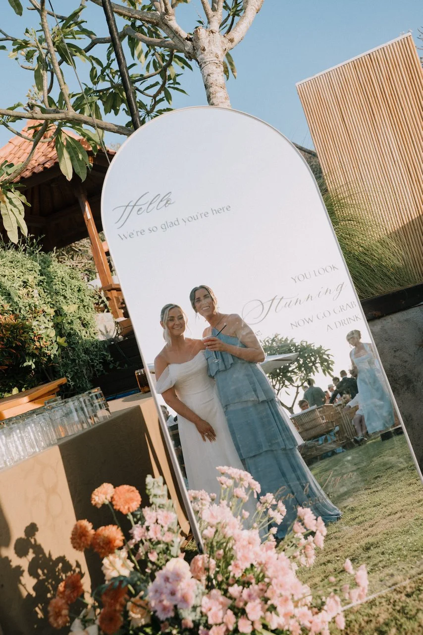 Large custom welcome mirror reflecting guests and floral arrangements at Uluwatu Cottages