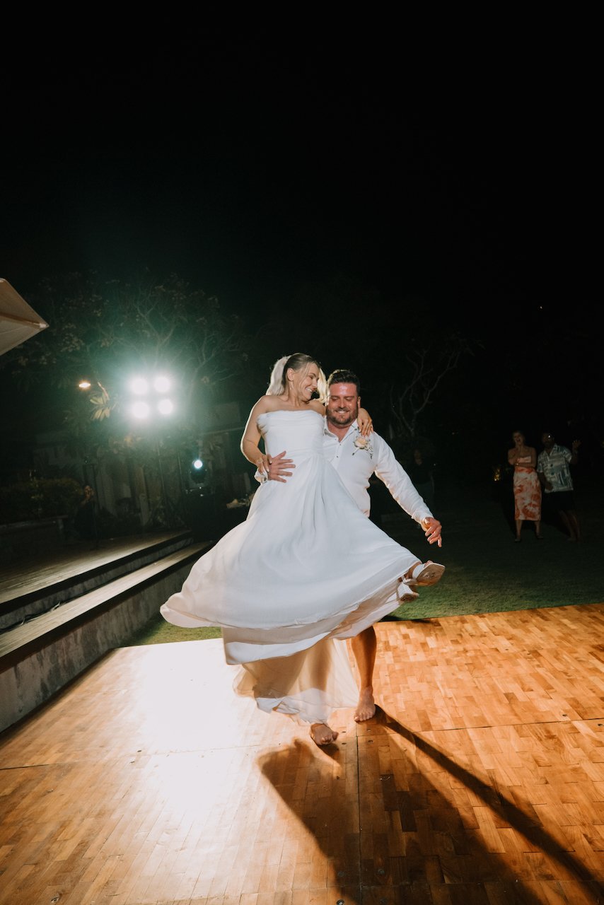 Groom Liam spinning bride Tegan on the wooden dance floor at night