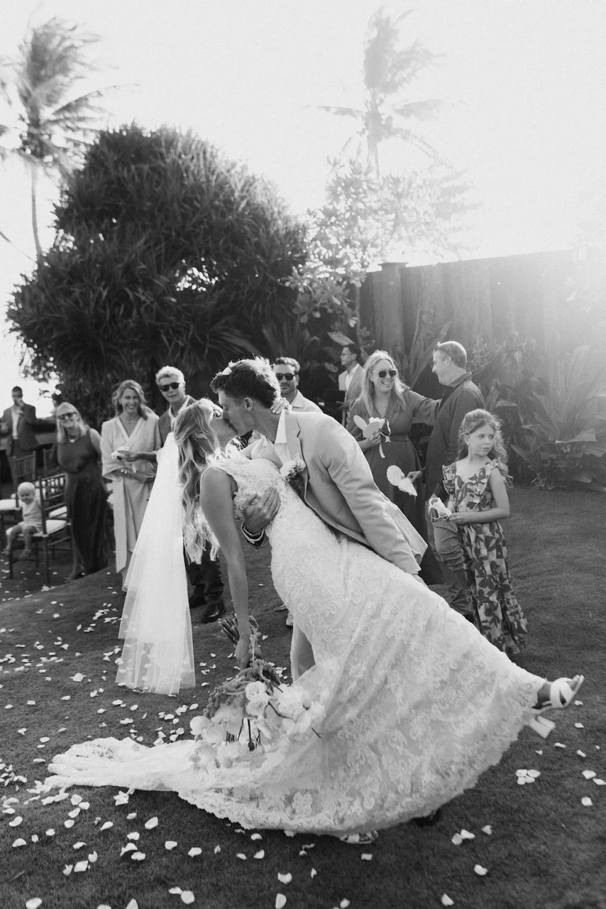 Black and white photo of the groom dipping his bride for a romantic kiss