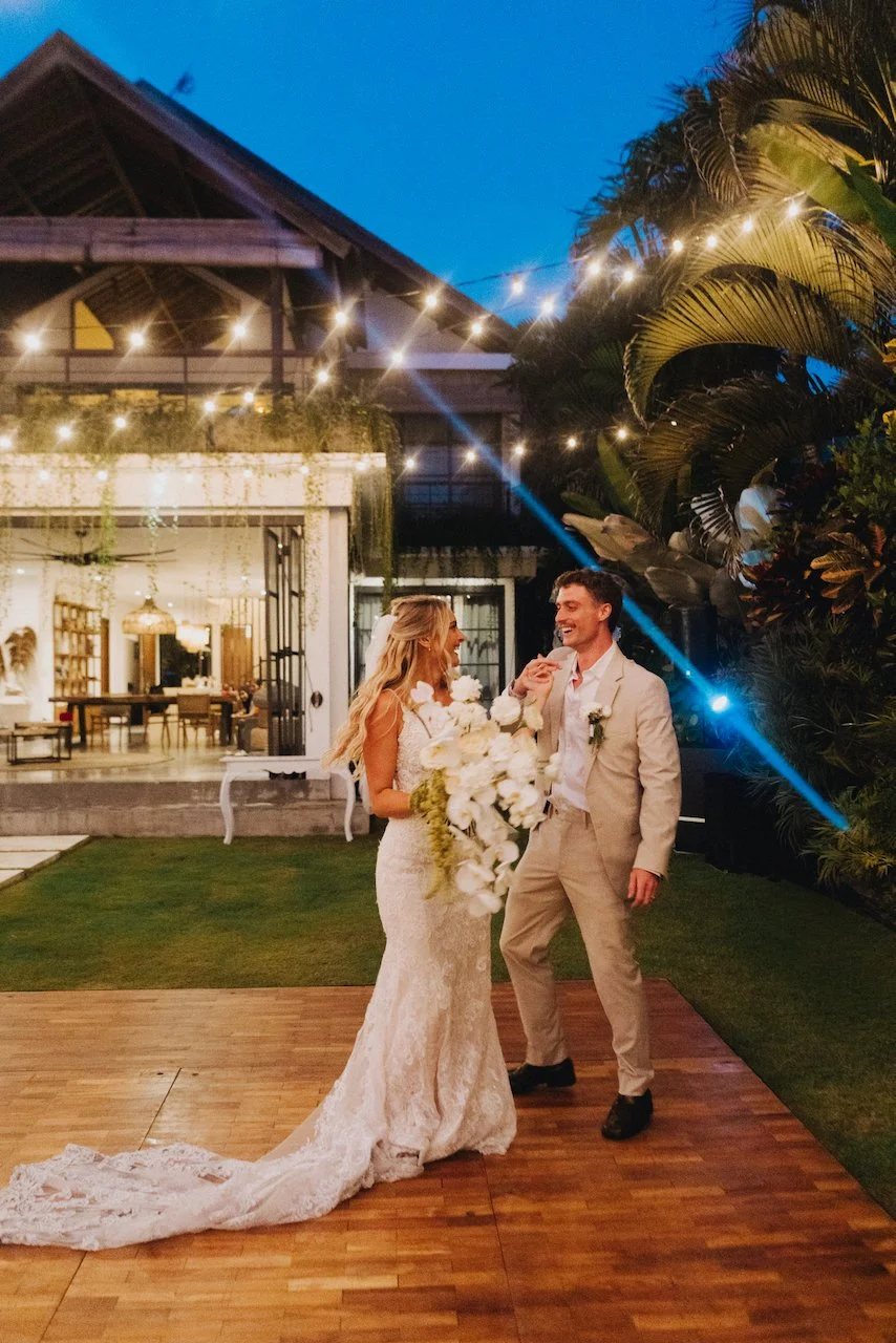 Devin and Daniella standing on an outdoor wooden dance floor outside their wedding villa