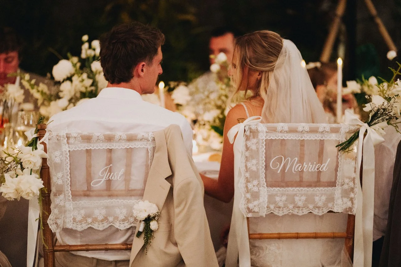 Just married signs on the backs of the bride and grooms chairs at their reception
