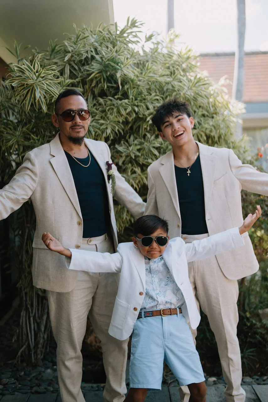 Groom John and his sons in light suits getting ready for a Bali vow renewal