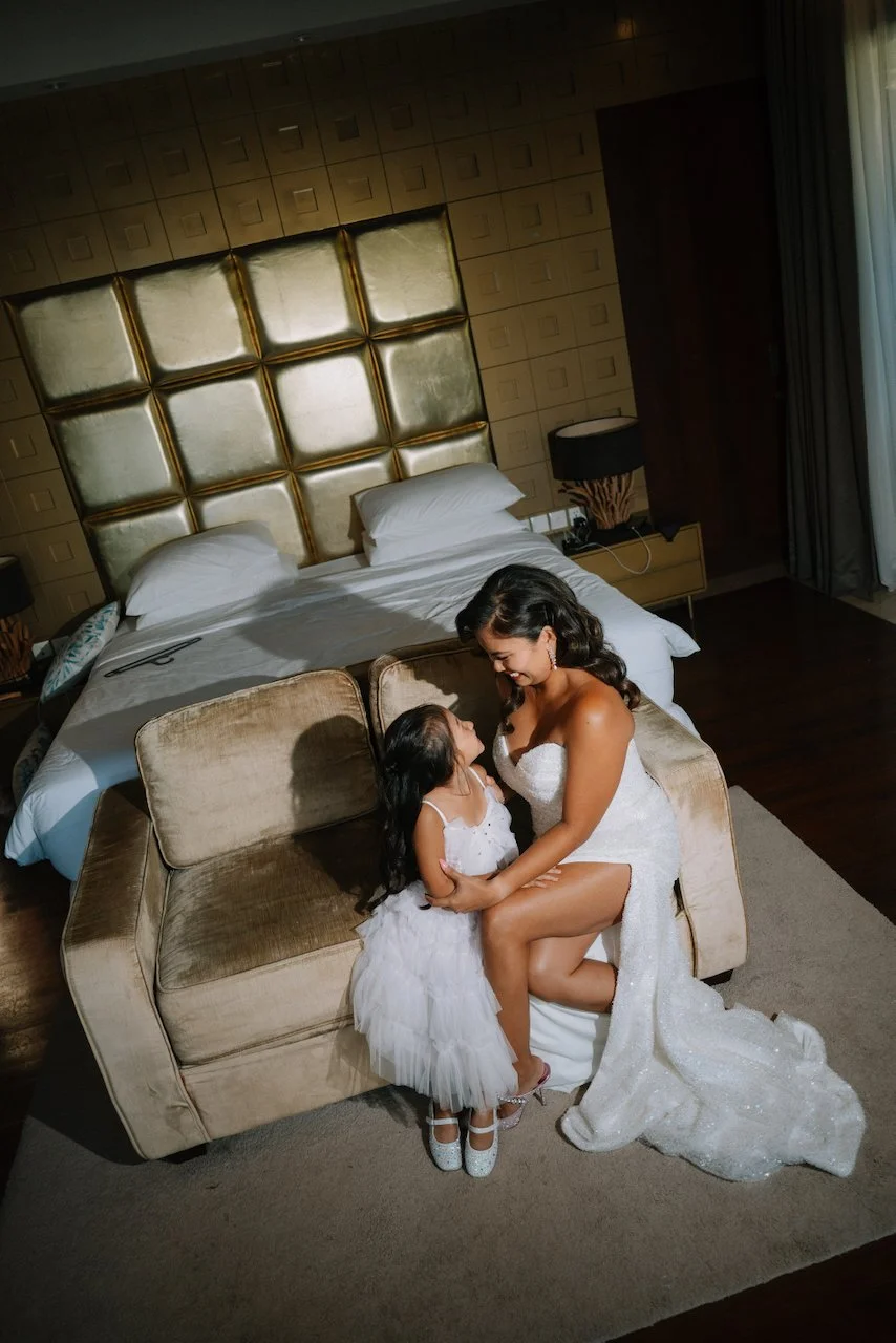 Bride Michelle in a white gown sitting with her daughter before the ceremony