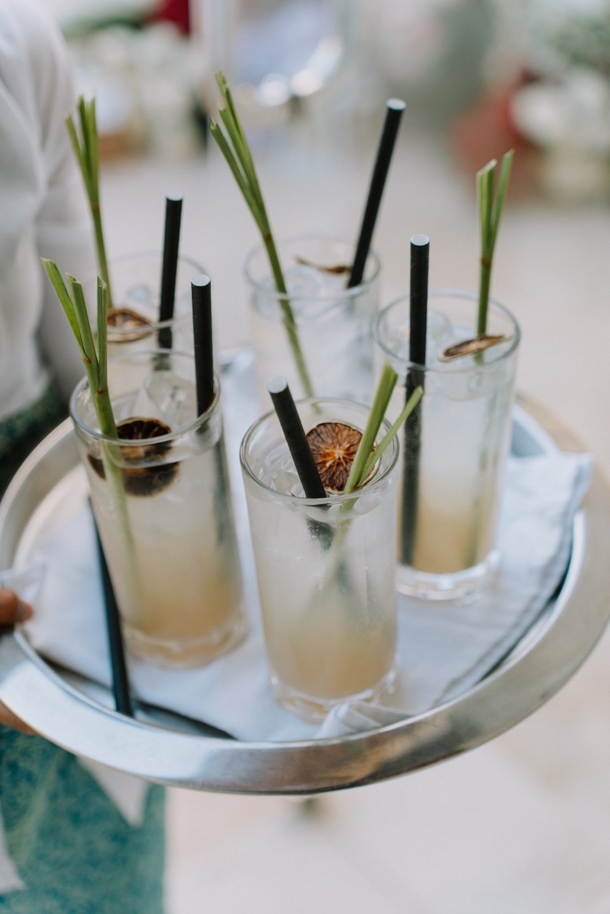 Tray of tropical signature cocktails with lemongrass garnishes