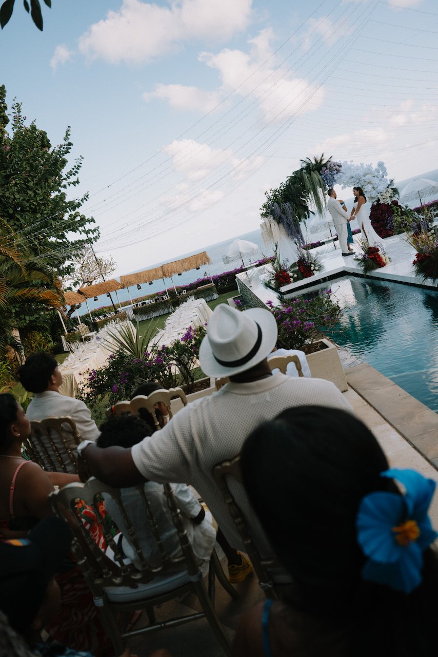 Guests seated watching a clifftop vow renewal ceremony overlooking the ocean