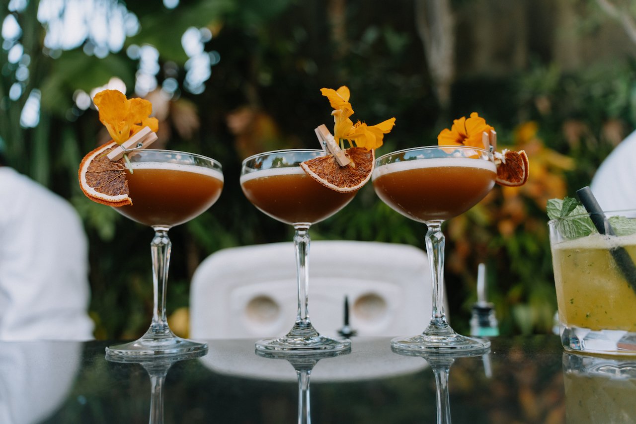 Close up of three orange signature cocktails garnished with dried citrus