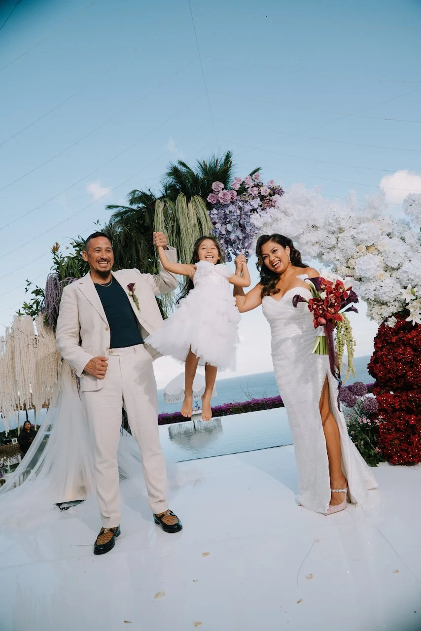 Groom John playfully lifting the flower girl after exchanging vows