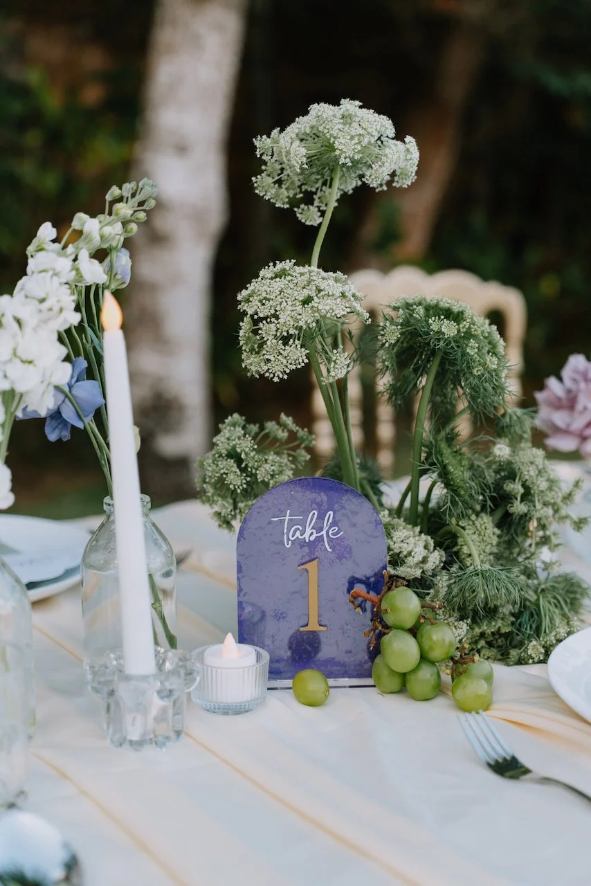 Elegant table setting detail with a purple table number and green grapes