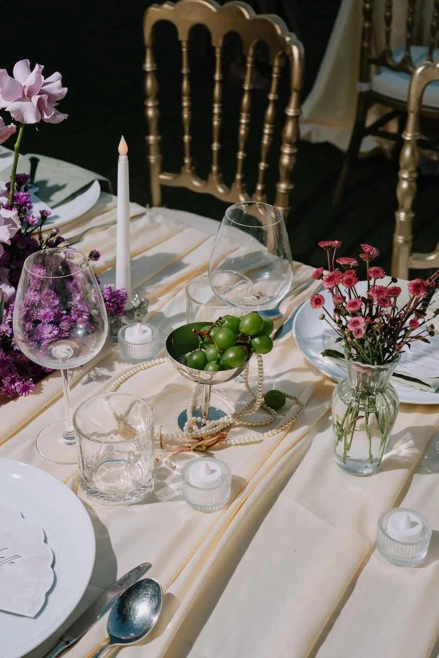 Close up of reception table styling with purple flowers and green grapes
