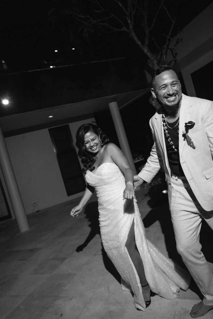 Black and white photo of Michelle and John entering their reception smiling