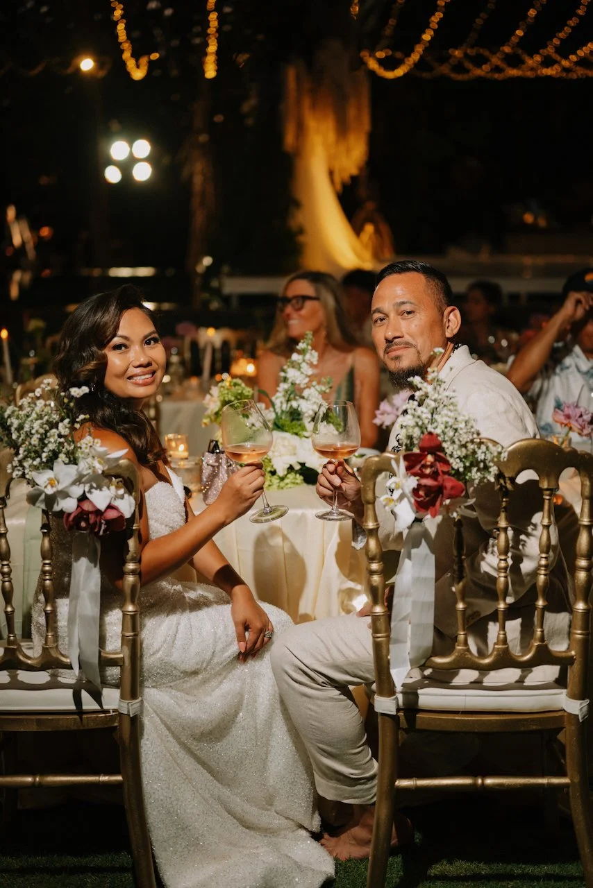 Couple smiling at their reception dinner table at Karang Saujana Bali