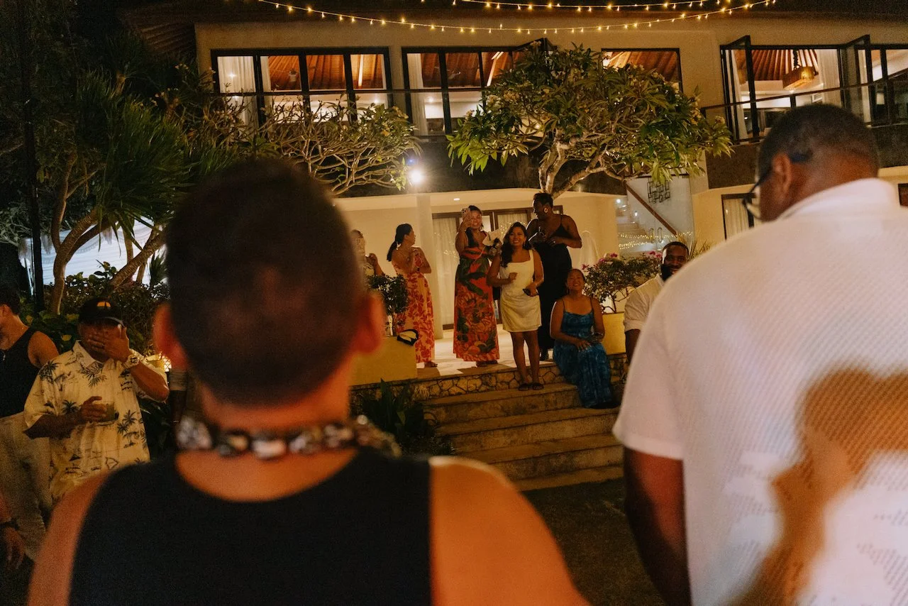 Guests watching the couple dance outdoors under magical string lights