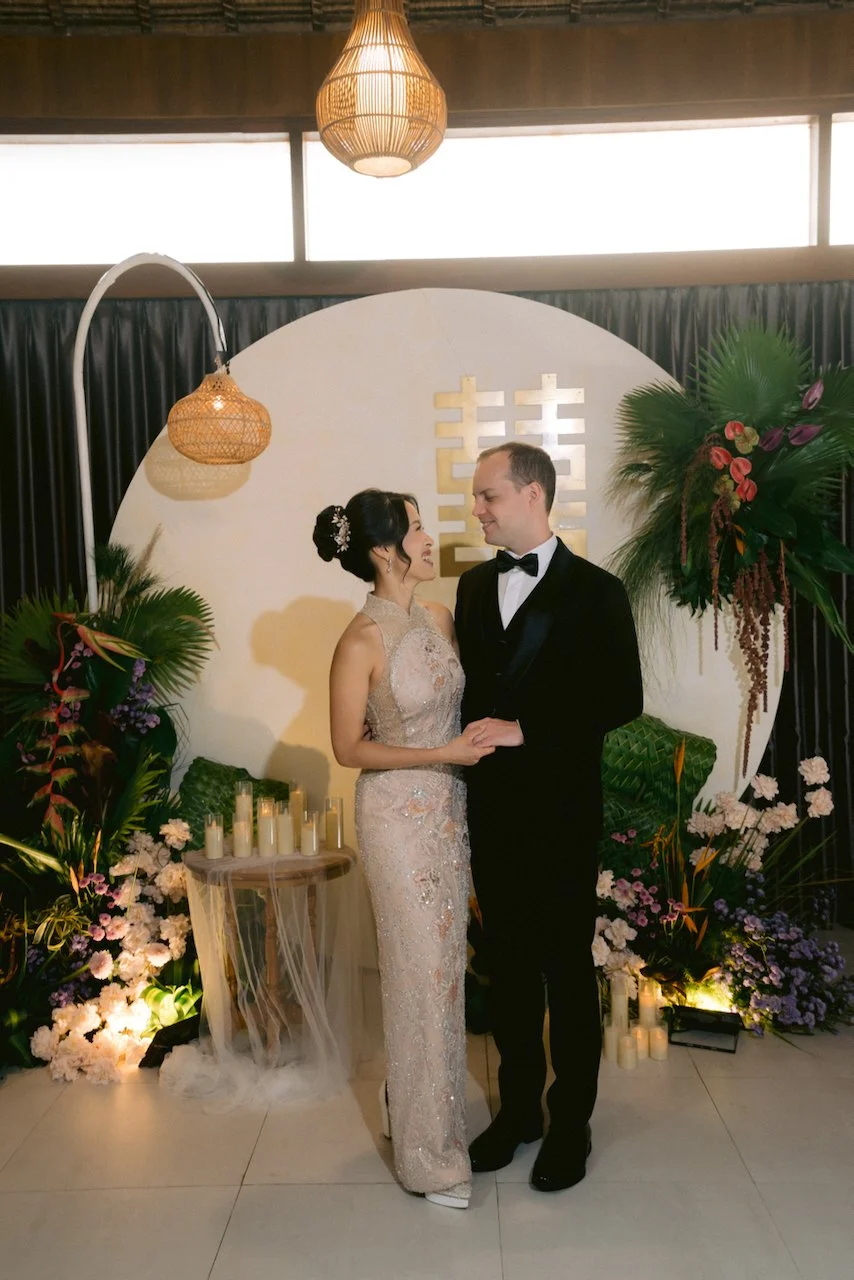 Felicia and Forrest standing at their tea ceremony altar with a double happiness sign