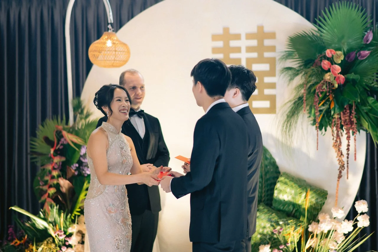 Parents handing a traditional red envelope to the bride and groom during their tea ceremony