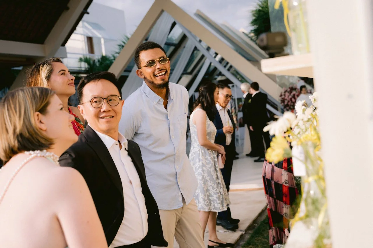 Wedding guests smiling and chatting outside an A frame chapel in Bali