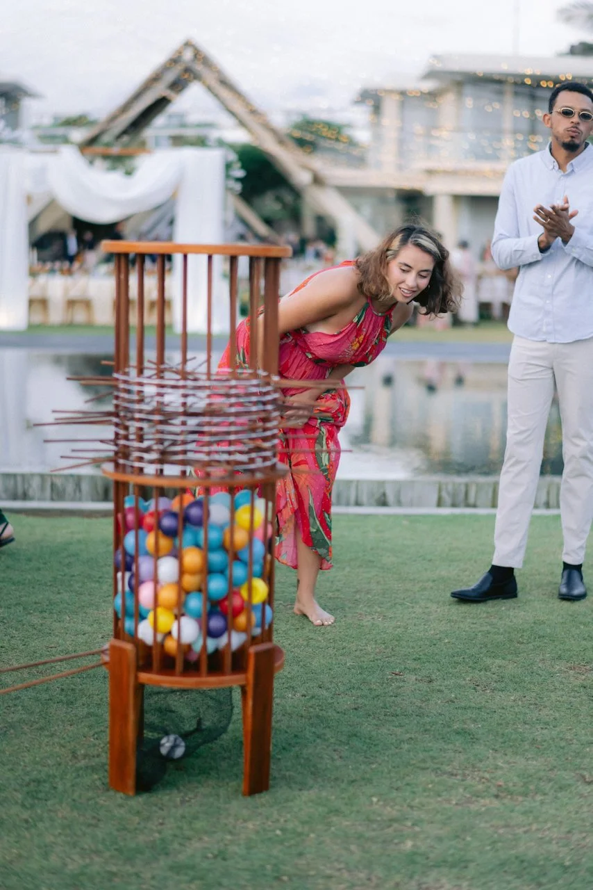 Wedding guest playing a wooden drop game during an outdoor cocktail hour