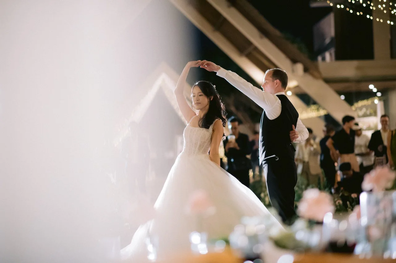 Groom twirling his bride during their first dance at a Bali destination wedding