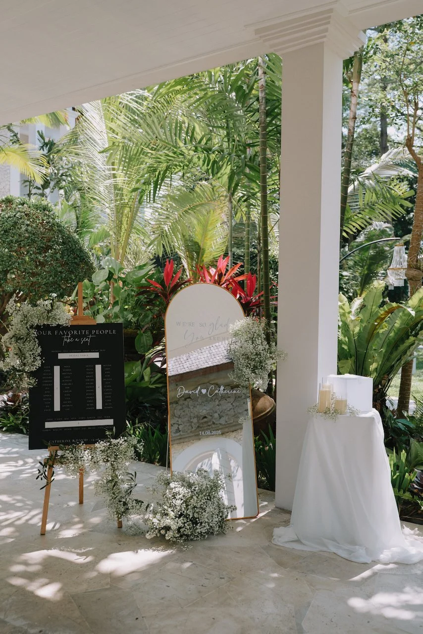 Arched welcome sign decorated with white flowers at a Bali villa entrance