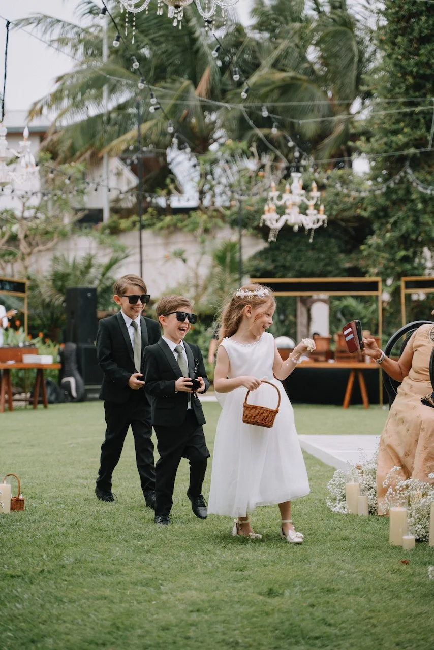 Flower girl and ring bearers walking down a grassy ceremony aisle in Bali