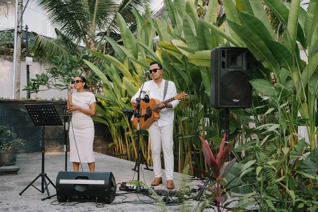 Acoustic duo performing live music for guests at a Bali wedding cocktail hour