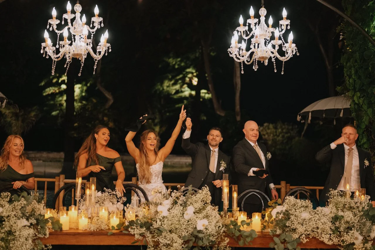 Catherine and David raising their hands while entering their wedding reception