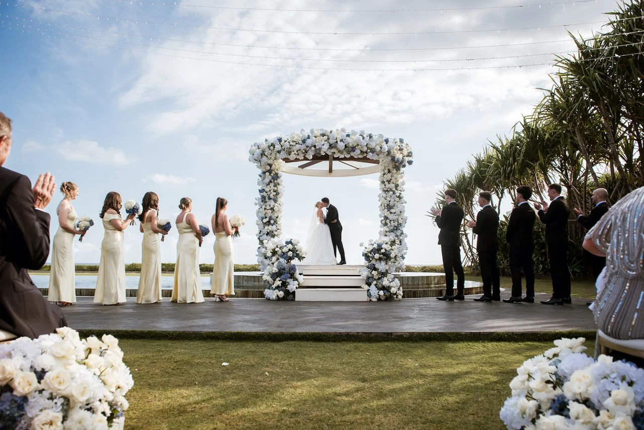 Wedding party gathered beside the ceremony aisle