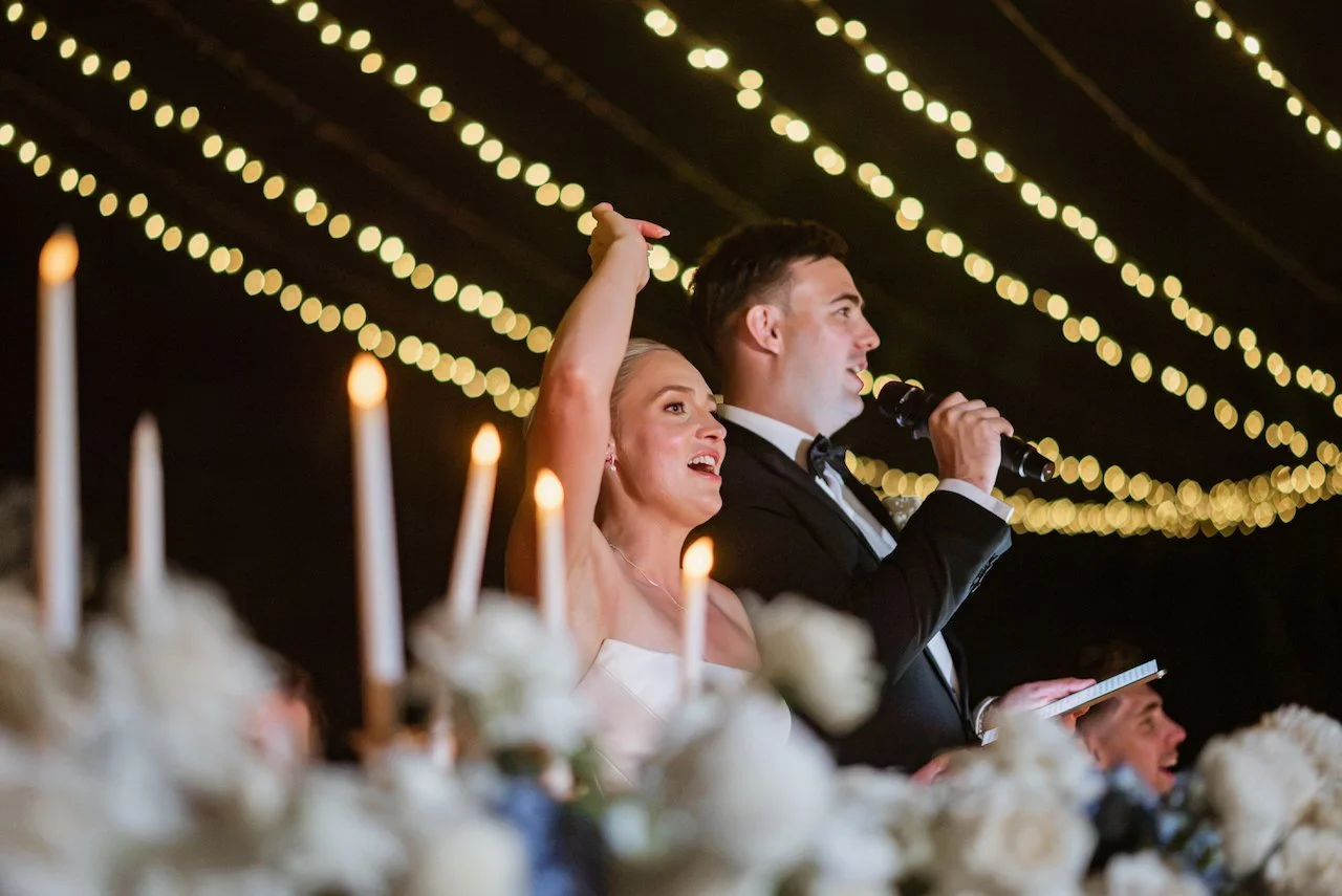 Bride and groom seated together beneath the reception lights