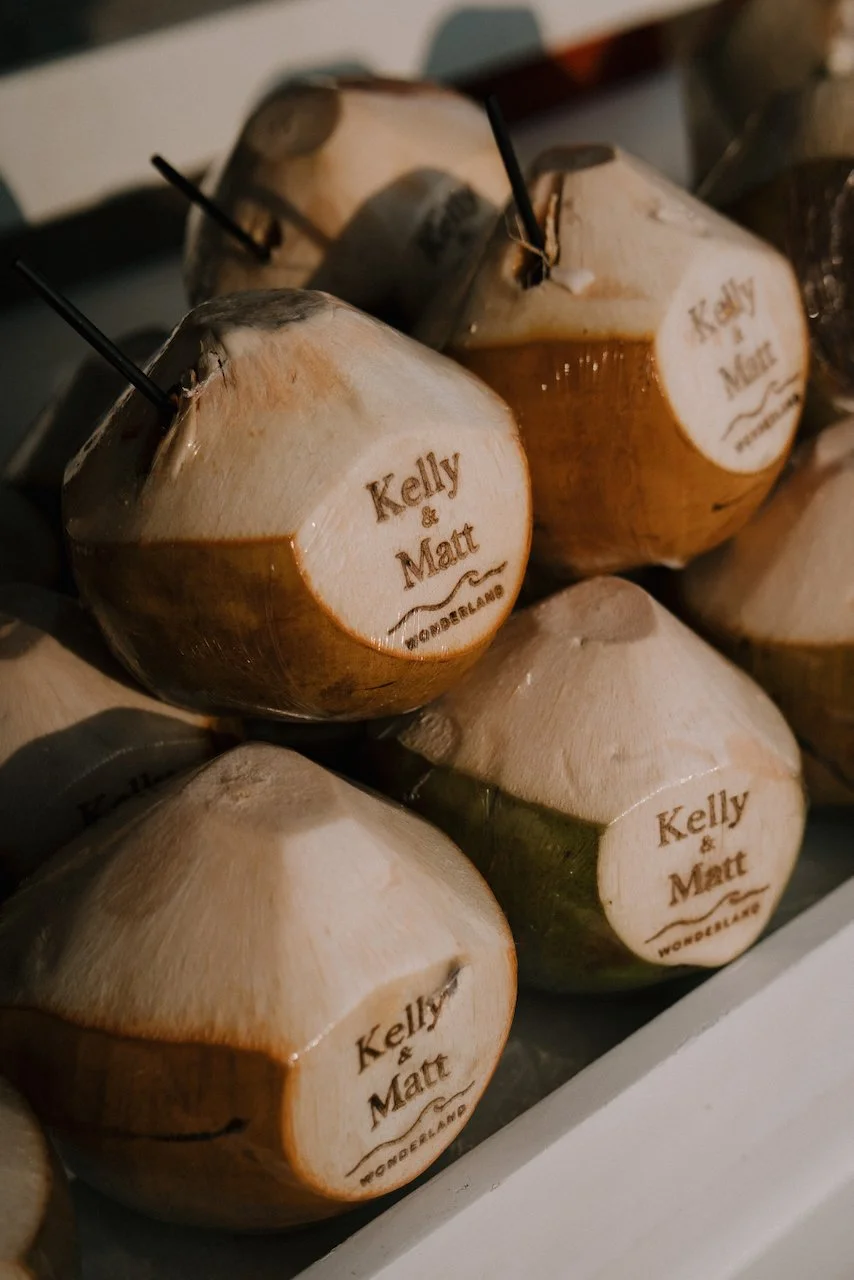 Fresh coconuts engraved with Kelly &amp; Matt and Wonderland, served as welcome drinks