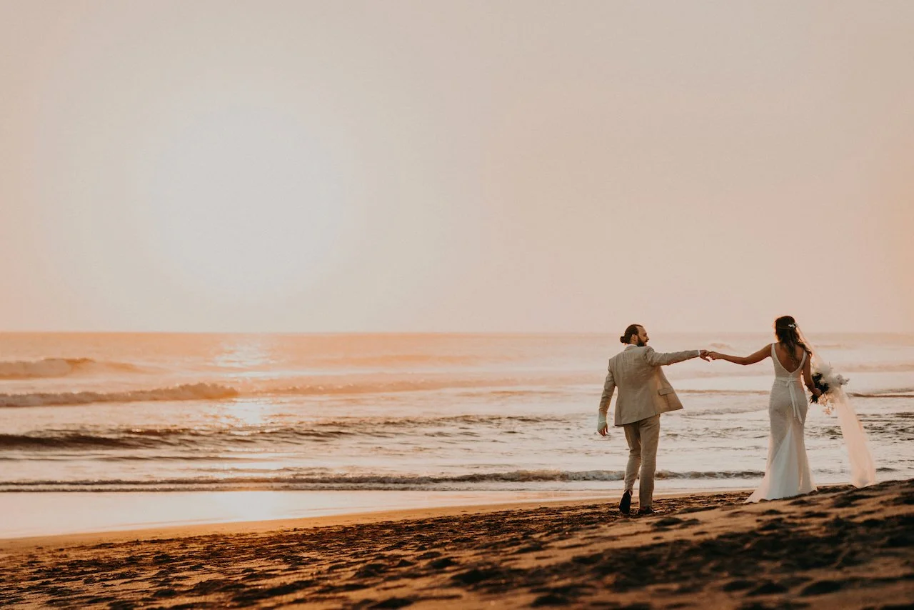 Carly and Seb walking on the beach at sunset at Villa Phalosa, Batu Belig, Seminyak, Bali