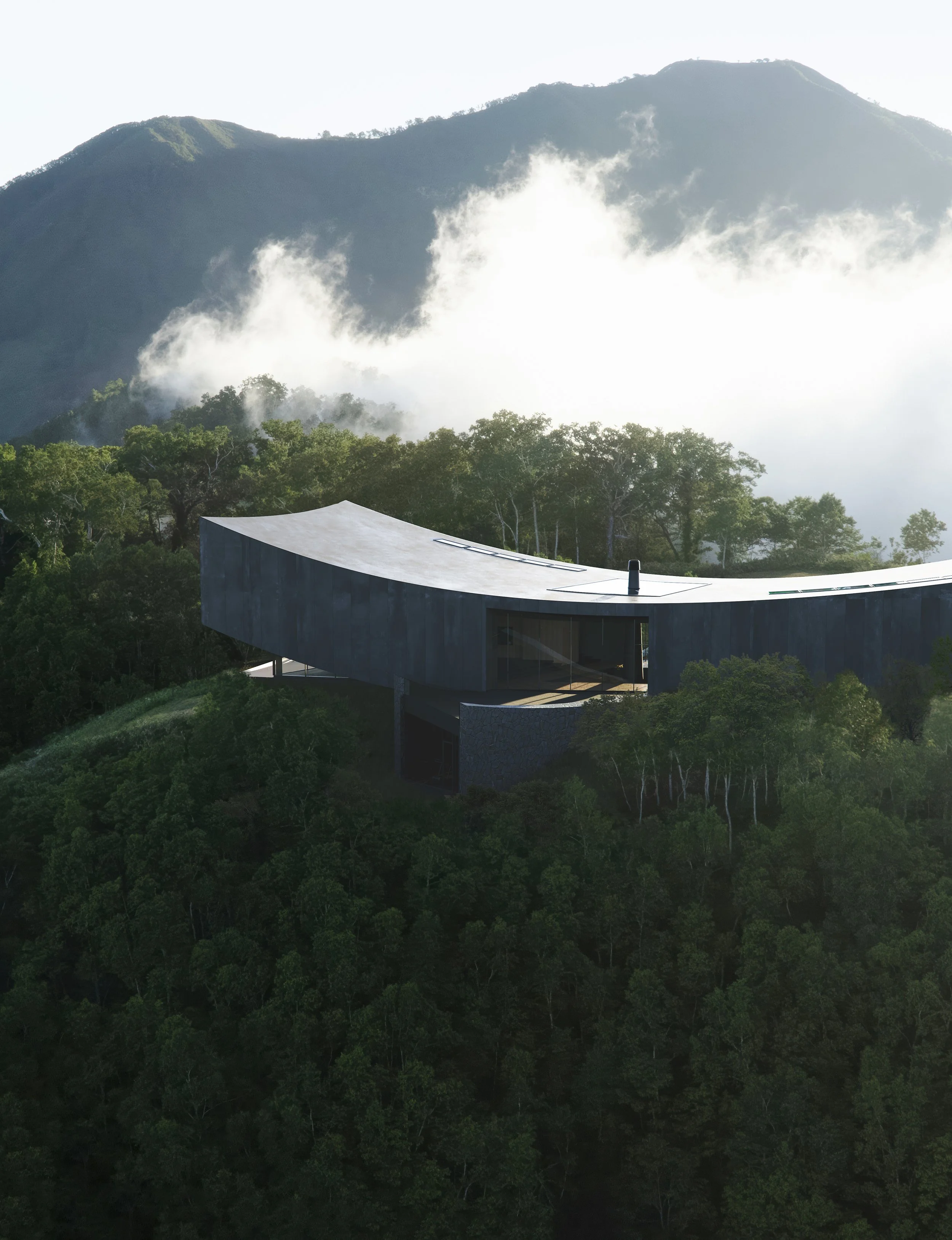 Modern house with curved roof, surrounded by dense green forest, mountain in the background with clouds and mist.