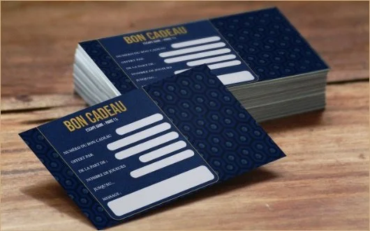 Cartes-cadeaux empilées sur une surface en bois, présentant des lignes à remplir avec des informations sur les cadeaux.