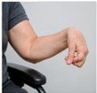 Person's arm and hand holding a key against a neutral background.