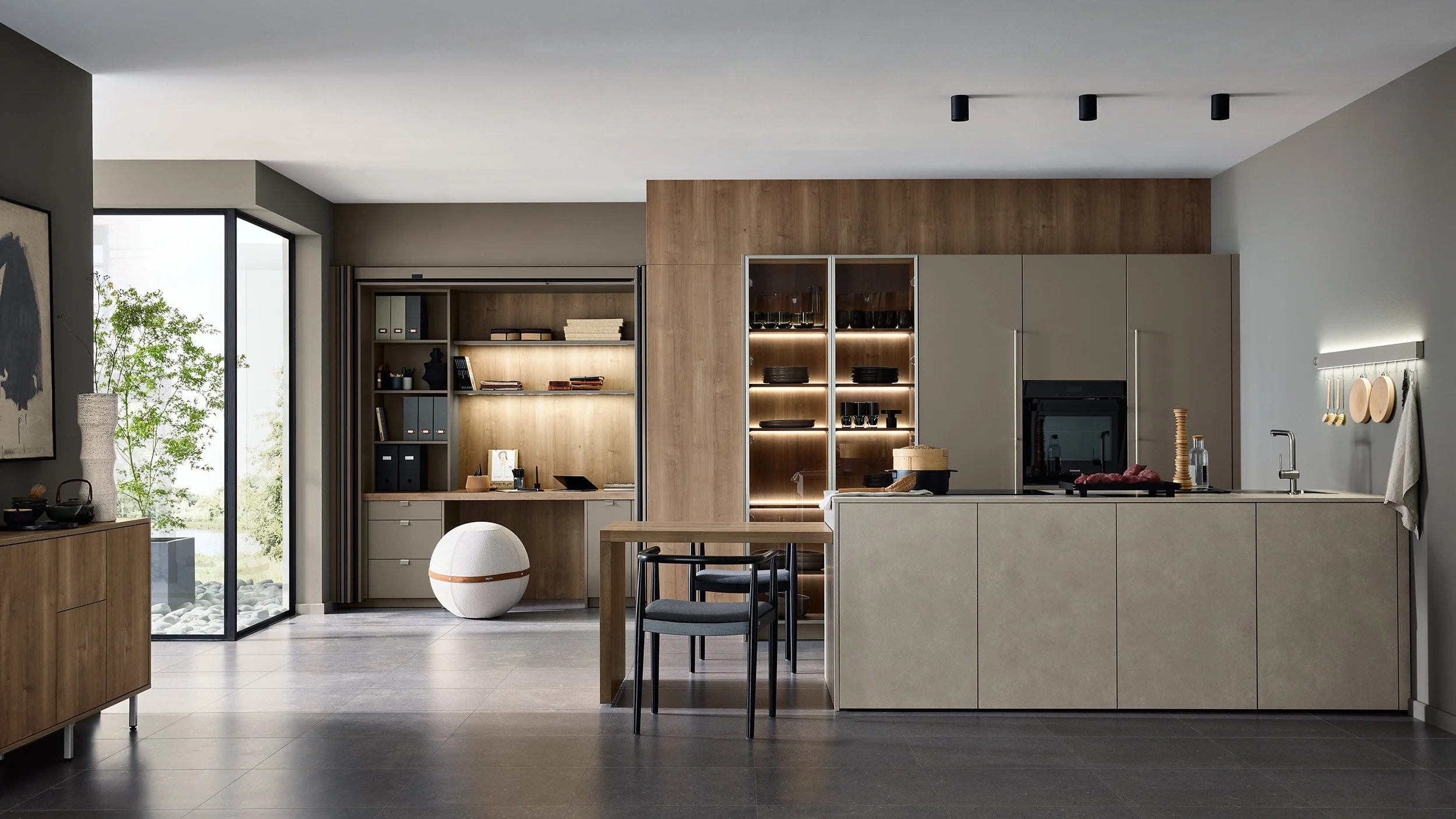 Moderne keuken met houten en beige kasten, een eiland met kookplaat, open planken en een grote glazen deur naar de tuin