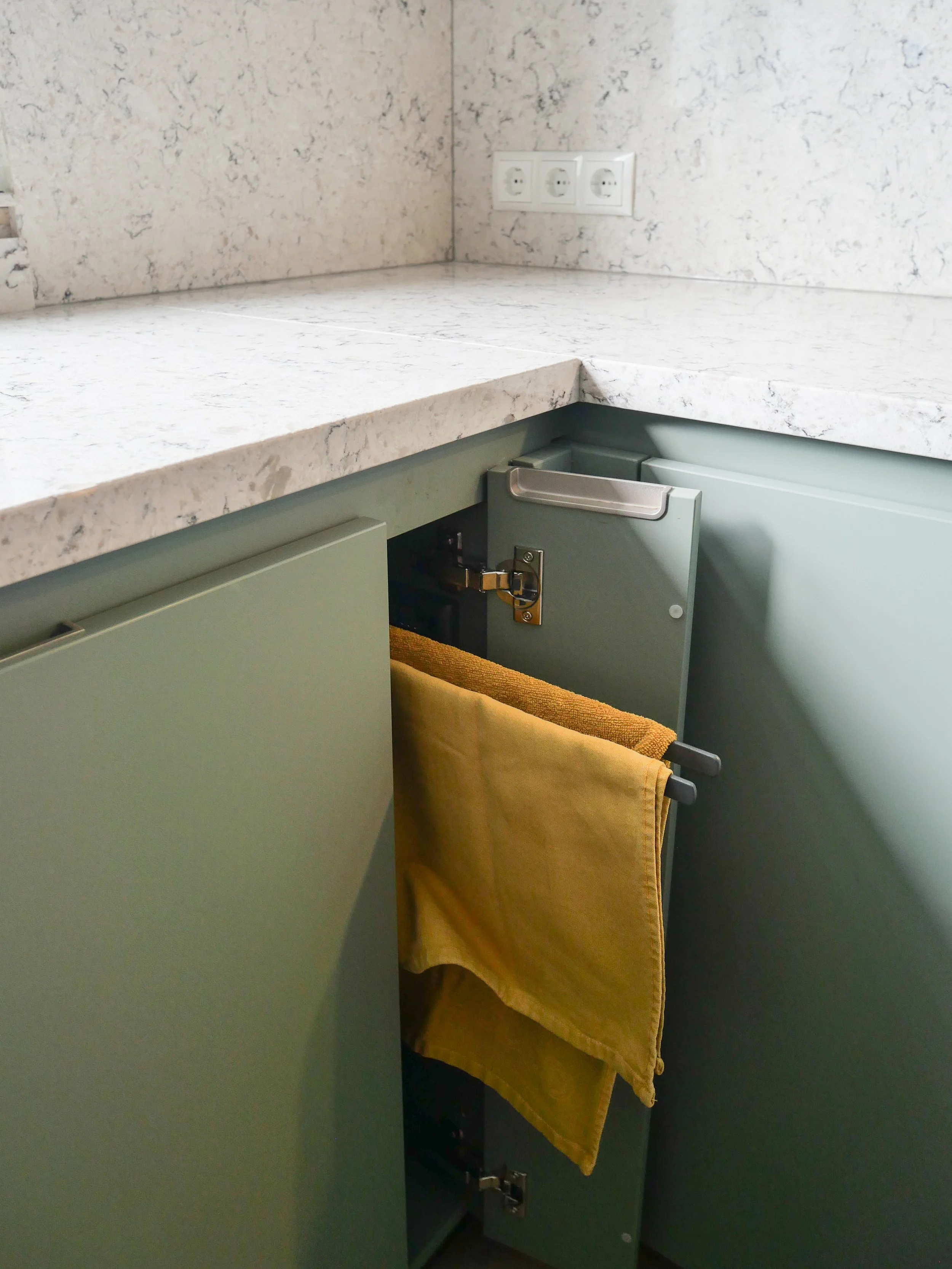 Keukenkastje met een geel handdoek op een handdoekrooster.