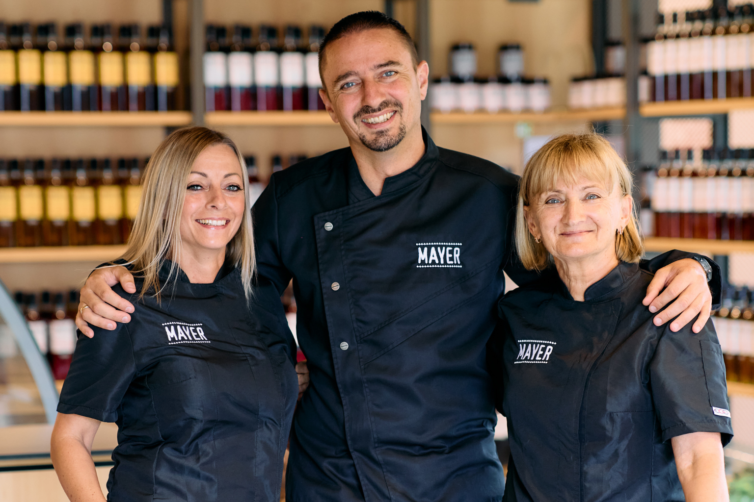 Péter Galajda with two members of the Mayer team in front of a display of Mayer syrups