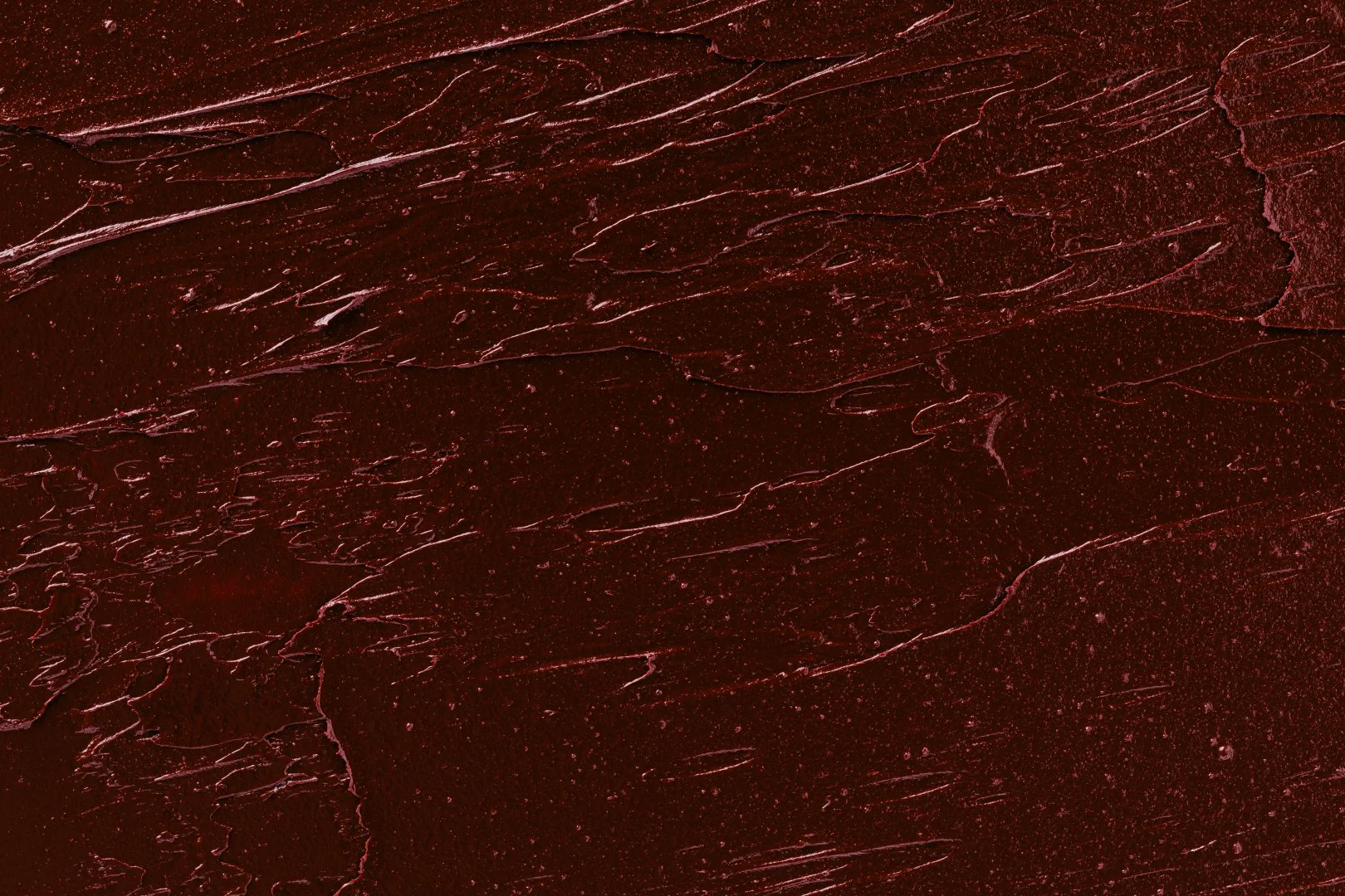 Textured swatch of burgundy lip gloss.
