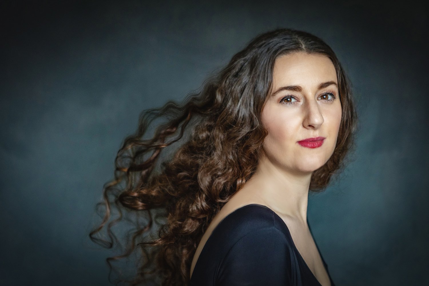 Italian woman with long flowing hair blowing in the wind during a professional glamour photoshoot