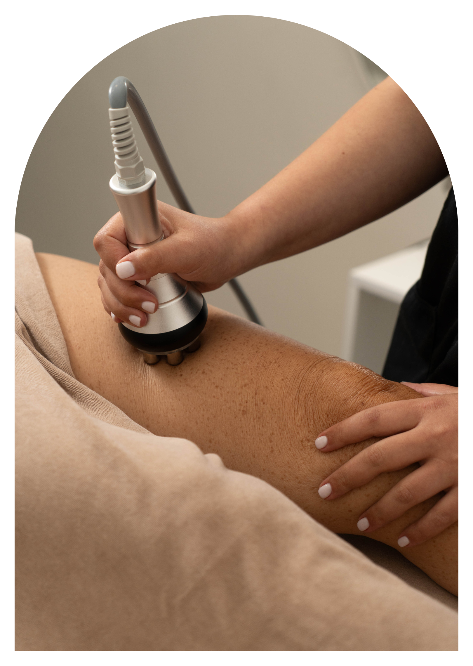 Une personne effectue une séance de physiothérapie ou de traitement médical, utilisant un appareil pour traiter la peau du bras d'un patient.